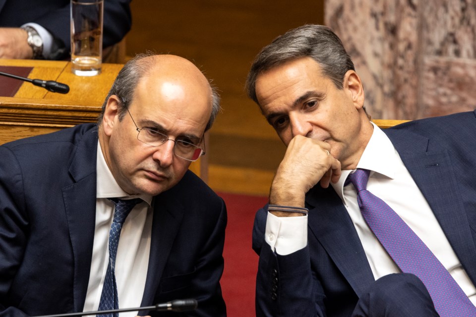 FILE - Greece's Prime Minister Kyriakos Mitsotakis, right, speaks with National Economy and Finance Minister Kostis Hatzidakis during a parliament session in Athens, Greece, Saturday, July 8, 2023. (AP Photo/Yorgos Karahalis, File)