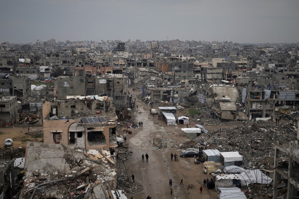 Palestinians walk surrounded by the rubble of destroyed homes and building in the Zeitoun neighborhood of Gaza City, Friday, March 7, 2025. (AP Photo/Jehad Alshrafi)