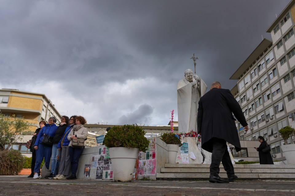 People pray for Pope Francis in front of the Agostino Gemelli Polyclinic, in Rome, Thursday, March 13, 2025, where the Pontiff is hospitalized since Friday, Feb. 14. (AP Photo/Andrew Medichini)