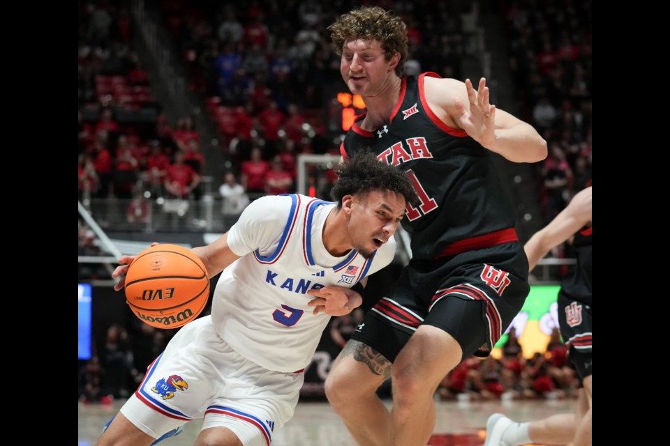 Kansas guard Zeke Mayo (5) drives to the basket as Utah forward Caleb Lohner (11) defends during the first half of an NCAA college basketball game, Saturday, Feb. 15, 2025, in Salt Lake City. (AP Photo/Bethany Baker)