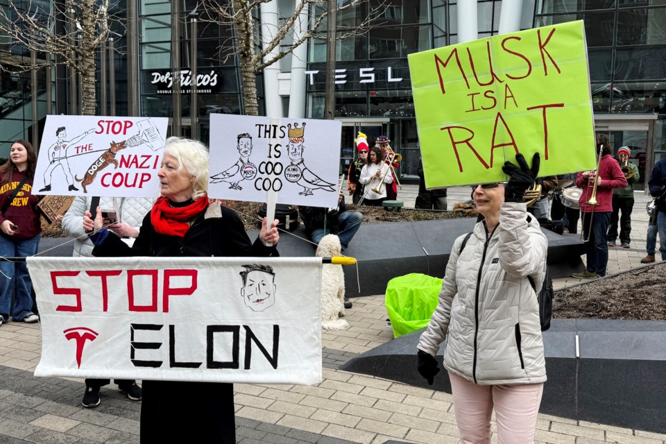 Protesters rally outside of a Tesla store in Boston, Saturday, March 1, 2025, against the company's CEO, Elon Musk, who is leading an effort to cut government jobs on behalf of President Donald Trump. (AP Photo/Rodrique Ngowi)