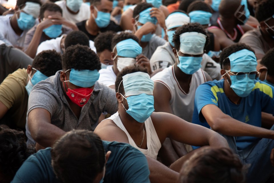 People from China, Vietnam and Ethiopia, believed to have been trafficked and forced to work in scam centers, sit with their faces masked while in detention after being released from the centers in Myawaddy district in eastern Myanmar, Wednesday, Feb. 26, 2025. (AP Photo/Thanaphon Wuttison)