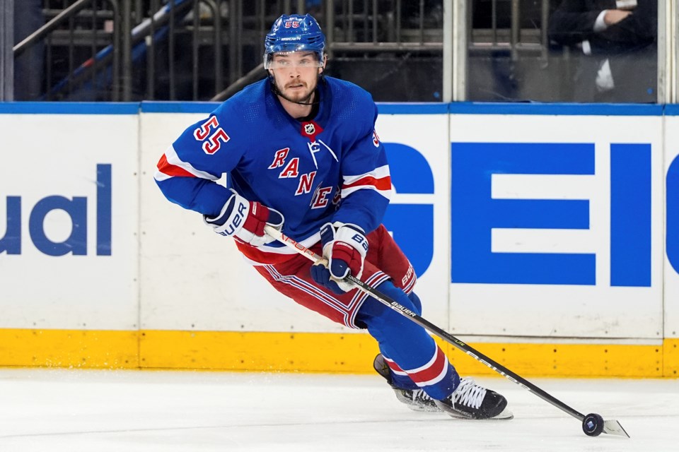 FILE - New York Rangers defenseman Ryan Lindgren (55) brings the puck up the ice during the third period of Game 1 of the NHL hockey Eastern Conference Stanley Cup playoff finals against the Florida Panthers, Wednesday, May 22, 2024, in New York. (AP Photo/Julia Nikhinson, File)