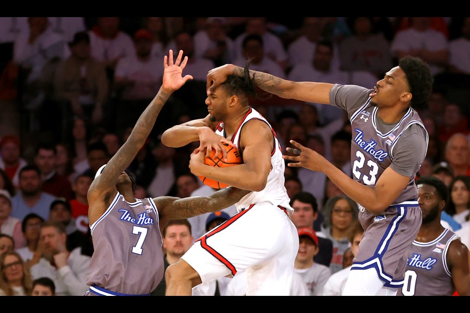 St. John's forward Zuby Ejiofor (24) grabs a rebound against Seton Hall forward Scotty Middleton (7) and center Emmanuel Okorafor (23) during the first half of an NCAA college basketball game, Saturday, March 1, 2025, in New York. (AP Photo/Noah K. Murray)