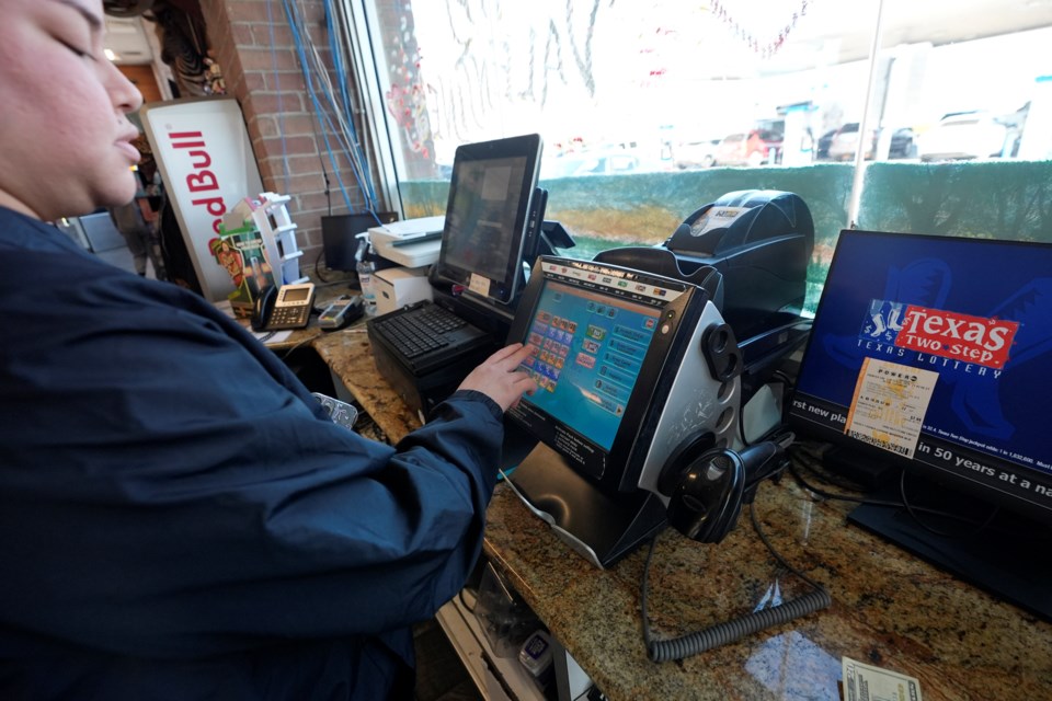 Edith Patlan uses a Texas Lottery terminal to complete at purchase of lottery tickets at Fuel City in Dallas, Wednesday, Feb. 26, 2025. (AP Photo/LM Otero)