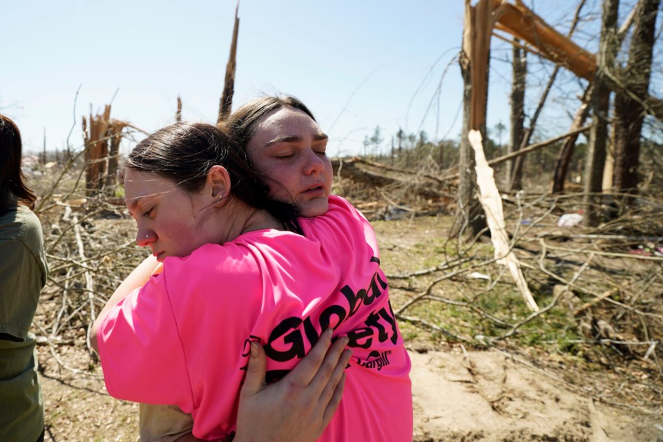 Hailey Hart, 21, right, hugs a friend, Sage Falgoust, 16, after recalling how she, her fiancee and their dogs rode out Saturday's tornado in their 1994 Toyota automobile, Sunday, March 16, 2025, in Tylertown, Miss. (AP Photo/Rogelio V. Solis)