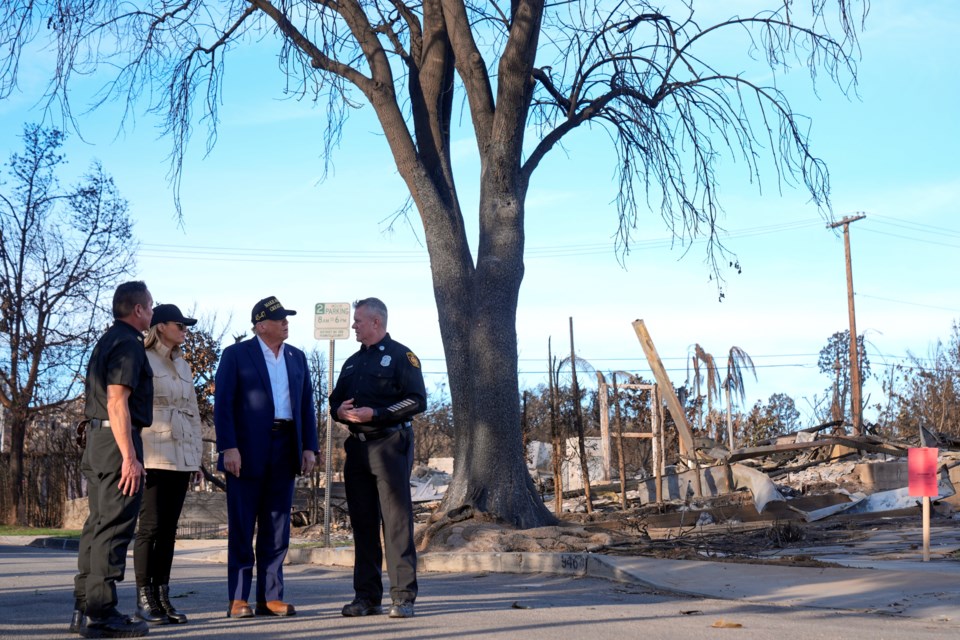 FILE - President Donald Trump and first lady Melania Trump walk with Jason Hing, chief deputy of emergency services at the Los Angles Fire Department, left, and Capt. Jeff Brown, chief of Station 69, as they tour the Pacific Palisades neighborhood affected by recent wildfires in Los Angeles, Jan. 24, 2025. (AP Photo/Mark Schiefelbein, File)