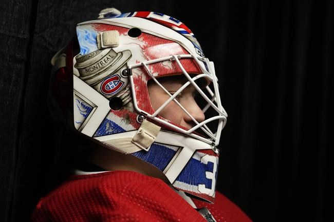 The puck bounces off the face mask of Montreal Canadiens goaie