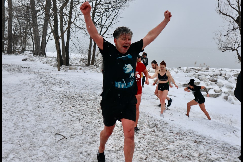 Veteran penguin Rick Mills runs to the trailer after a dip in the frigid water.