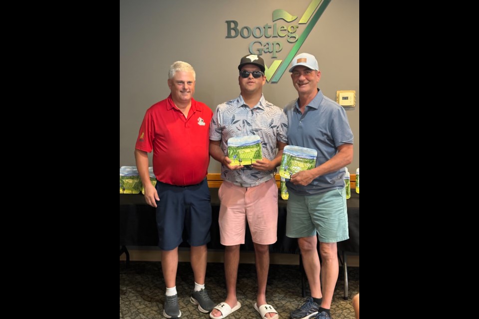 Hayden Foulds, middle, and his dad David, right, recieve accolades after Hayden finished second in the the B1 men’s division at the International Sports Promotion Society HANDA Canadian Blind Golf Open Championship.