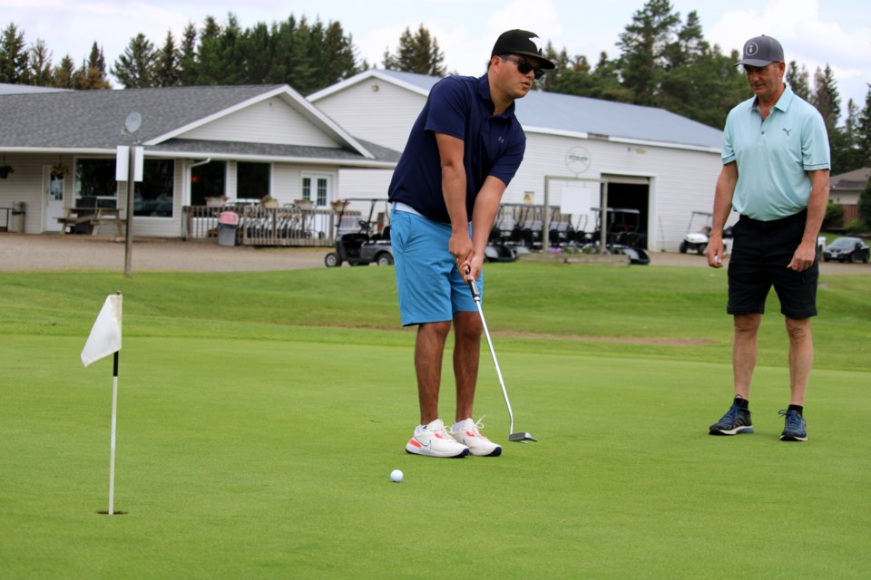 Visually impaired golfer Hayden Foulds works on putting while his dad David watches on during a practice session at the Northern Lights Golf Complex on Friday.