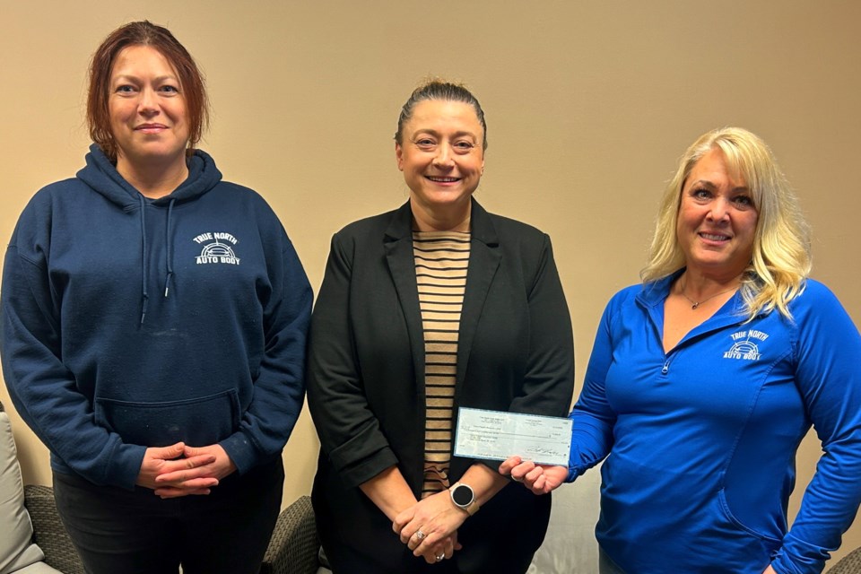 Risë Thompson (L)  and Sandee Strahan (R)  from True North Auto Body present a $2,800 check to DPRC Executive Director, Betsy Cronkhite-Huggett Friday afternoon.