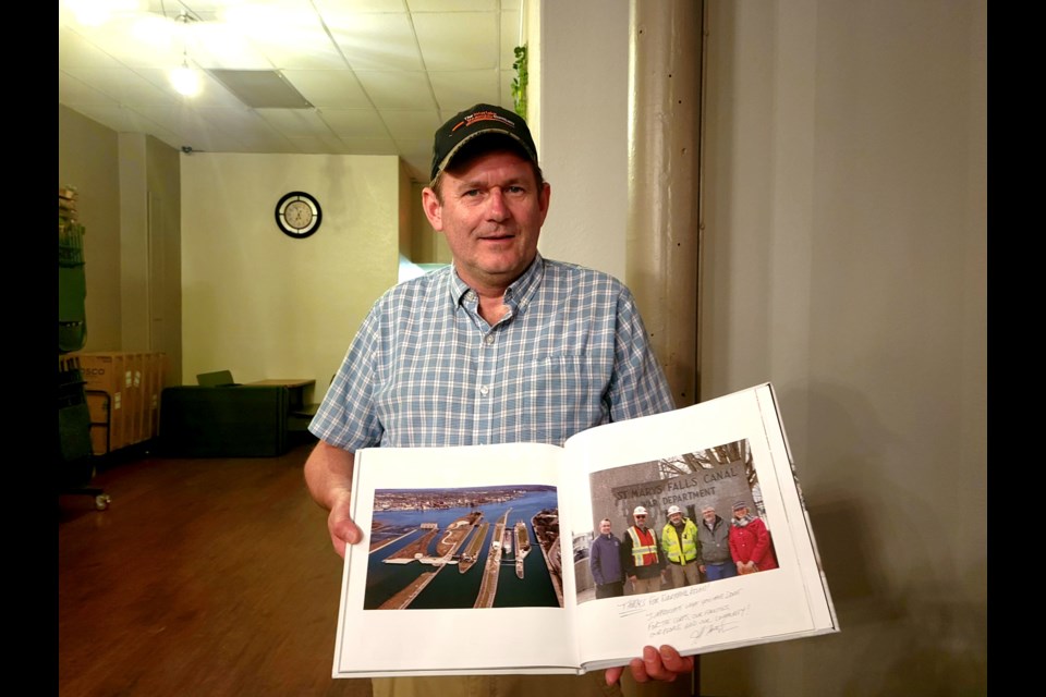 US Army Corps of Engineers Area Engineer Kevin Sprague holds 30 years of memories at his retirement party at Three One Three on Thursday, June 16