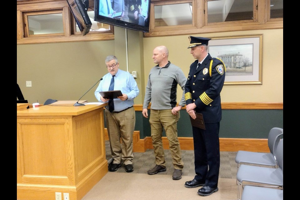 Sault Ste. Marie City Mayor Don Gerrie presents Sgt. John Weist with a proclamation and plaque to thank him for 25 years of service as a patrol officer, sniper, evidence technician, and Sault Area Narcotics Enforcement (SANE) detective during a regular city commission meeting on Tue, Jan. 3, 2023