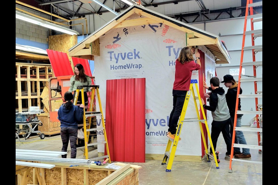 21 Sault Area High School & Career Center Construction Technology students finish up the International 500 Snowmobile Race Track's new safety shack under the direction of Trevor Paulus on the morning of Friday, Jan. 27, 2023