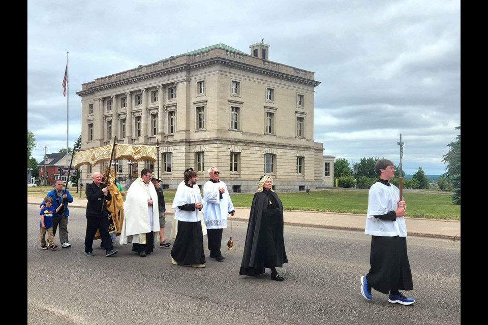 Joined by Knights on Bikes, approximately 100 Holy Name of Mary parishioners and neighbors walk more than 1.25 miles on the afternoon of Sunday, June 11, 2023 to proclaim the transubstantiation of bread and wine into the body and blood of Christ, beginning and ending at the Roman Catholic Church to close with Benediction prayer