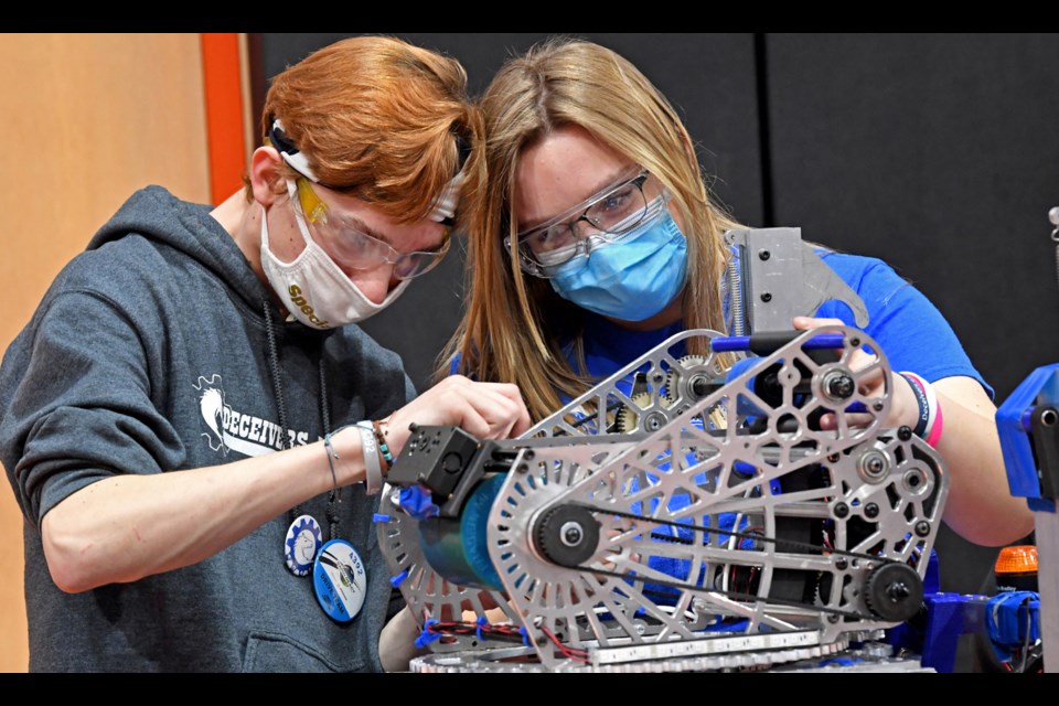 Siblings Braedon and Camela Kemp tune gears in their Brimley High School entry during a FIRST Robotics competition hosted last weekend, March 17-19, in Escanaba, Mich. The gearwork gives the robot mechanical advantage to clear obstacles and shoot targets during qualifying heats held over two days. 