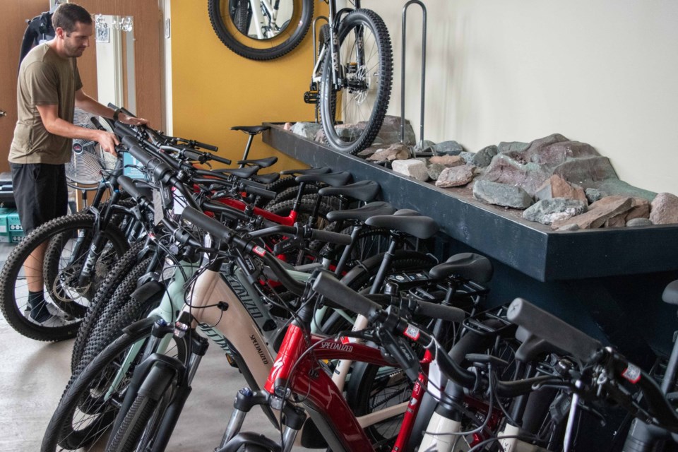 Jacob Douglas, co-owner of Lakeshore Bike in Marquette, moves an e-bike back into a selection of e-bikes at his shop