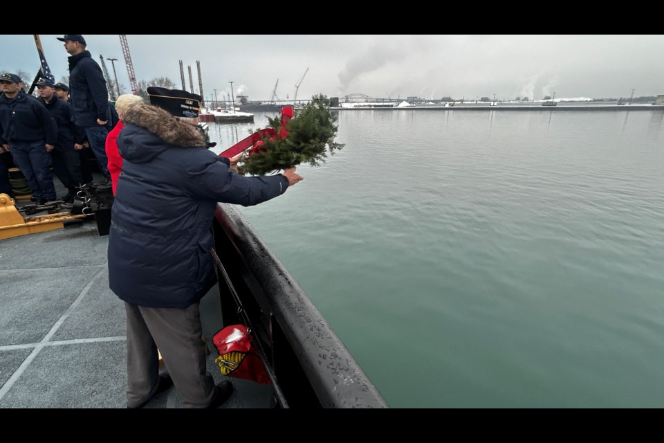 Chaplain, and Korean War veteran, Carl Eagle toss a memorial wreath into the St. Marys River.