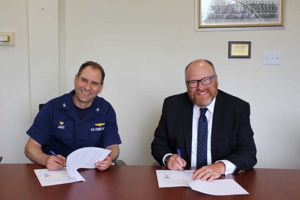 LSSU President Dr. Rodney S. Hanley (right) and Sector Sault Commander Capt. Anthony Jones renew the annual tuition agreement on June 13, 2022.