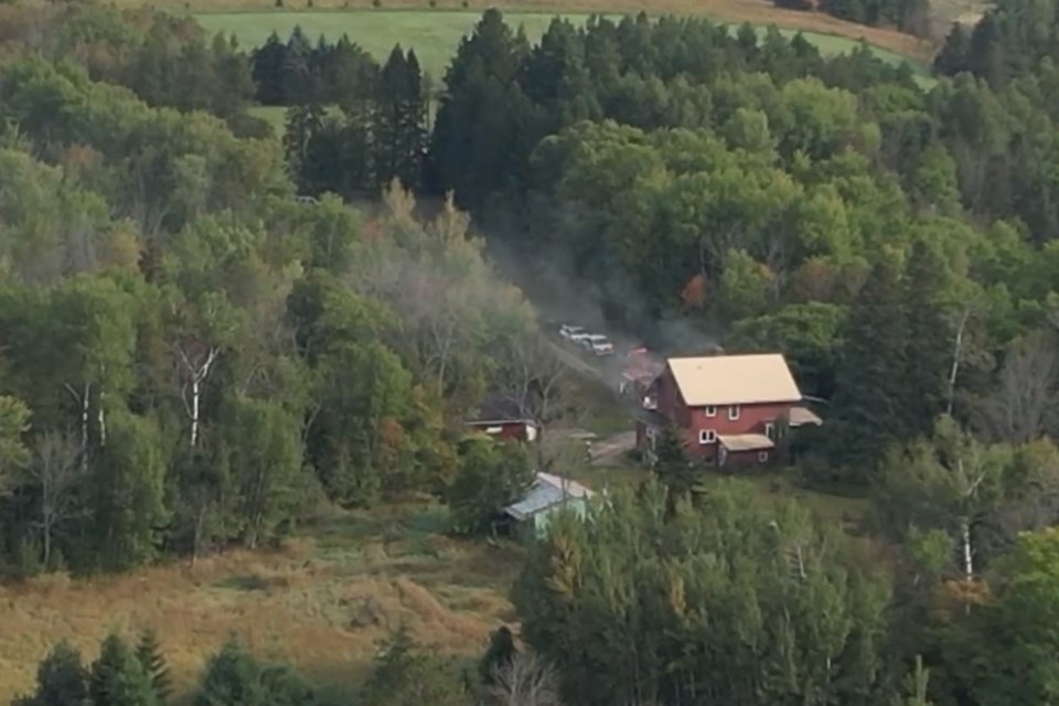 The three-story house is nestled in the woods on Zimmerman Road off Shunk Road in Soo Township.  This drone shot was taken above 4 Mile Road looking north.  