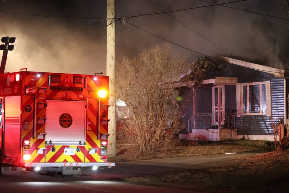 Firefighters try to contain a fire on Blake Ave. just before midnight on Easter Sunday.