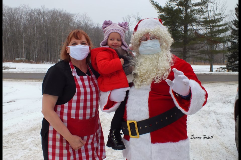 Claire Wallace (2), received a special hug from Santa and Mrs Clause (Roy and Mary Lou Eckmeier) before Santa and his entourage set out to collect for the St. Joseph Island and Area Food Bank