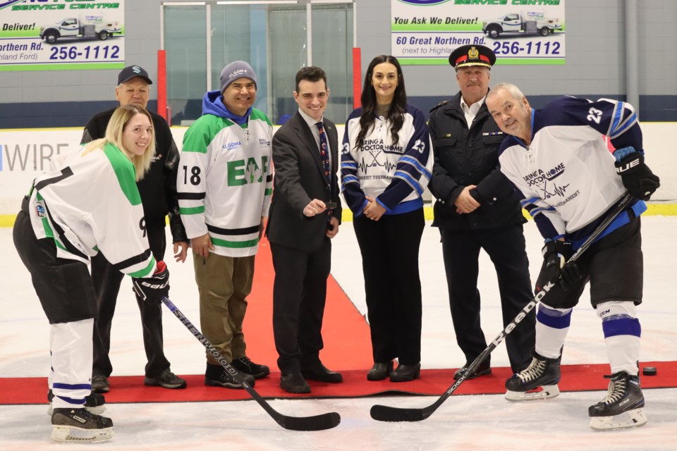 Fourth-year NOSM student and Sault native Adriane Bruni (third from right) helps with the ceremonial puck drop at the 17th annual Bring a Doctor Home hockey tournament alongside Kerri Ostroski, John Lewis, Algoma Steel CEO Michael Garcia, Mayor Matthew Shoemaker, Sault Police Chief Hugh Stevenson, and Kevin Punch.