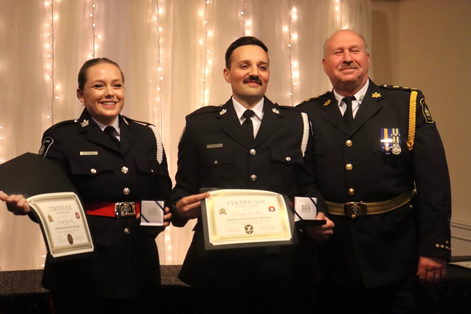 Constables Jamie Peace and Chris Perri accept the Peace Officer of the Year award from Sault Police Chief Hugh Stevenson inside the Grand Gardens on Wednesday night.