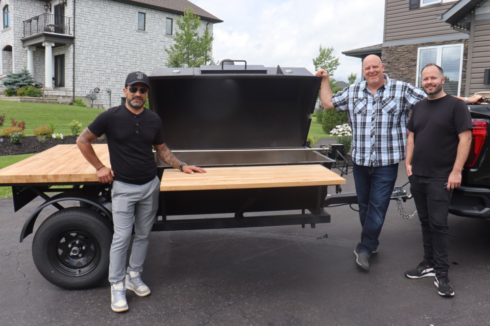 Local welder Carmen Cavaliere (middle) shows off his massive custom-built porchetta roaster alongside his relatives Serge Cavaliere (Giovanni's co-owner) and Tony Cavaliere.