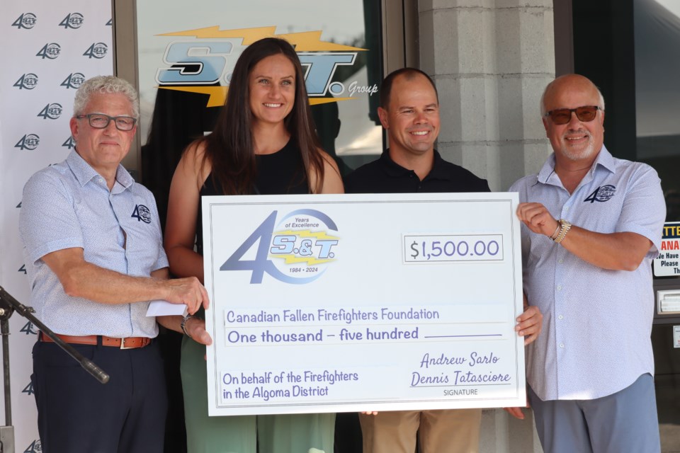 Danielle Buckner and Jeremy Van Hoek (centre) are presented with a $1,500 cheque from S.&T. co-founders Andrew Sarlo and Dennis Tatasciore for the Canadian Fallen Firefighters Association during 40th annual celebrations outside S.&T. facility on Wednesday. 