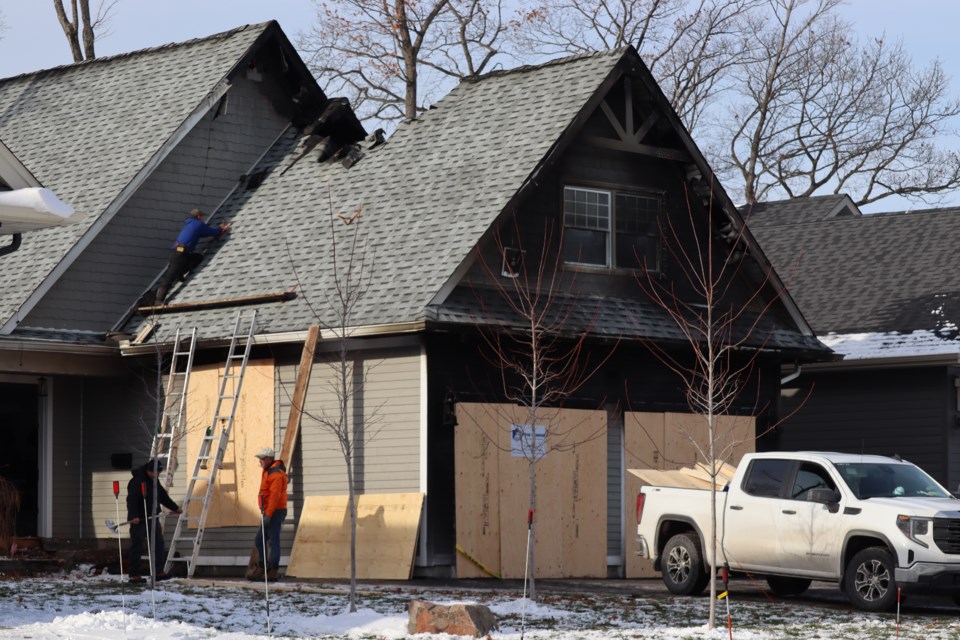 The attached garage of a Crimson Ridge Drive home is boarded up after flames broke out at the north-end residence on Nov. 24, 2023.