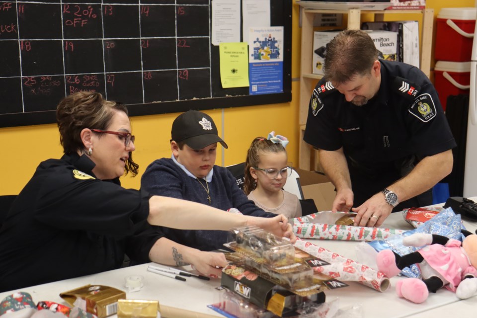 Local law enforcement helped children with their holiday shopping and wrapping as part of the annual Cops and Kids initiative on Dec. 9, 2023. 