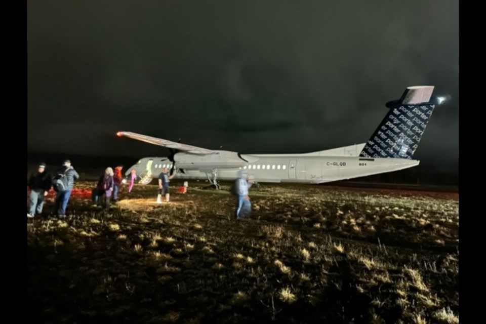 A reader-submitted photo shows a Porter Airlines aircraft sitting beside a runway at the Sault Ste. Marie Airport after it skidded off the runway during a late evening landing, April 16, 2023.