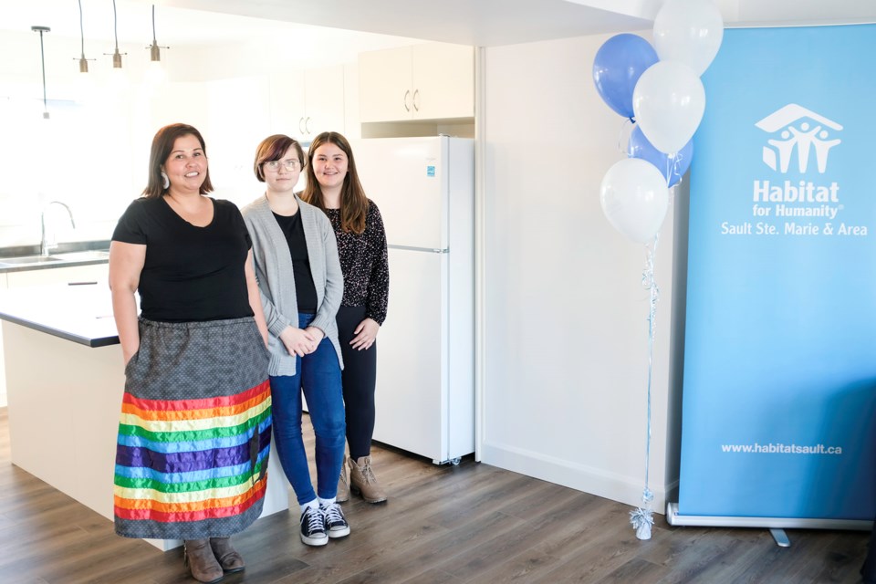 Samantha Kyle and her two children Rylee and Michaela seen during the dedication ceremony for their new home as part of the most recent build by Habitat for Humanity Sault Ste. Marie. Kyle wore a ribbon skirt that she sewed herself for the ceremony.