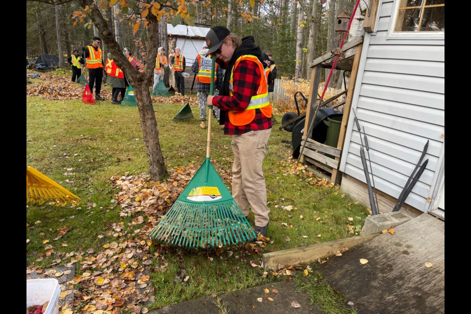 A crew of students rake up leaves at a home on Westridge Road Saturday as part of the annual Trades Day of Caring event. 