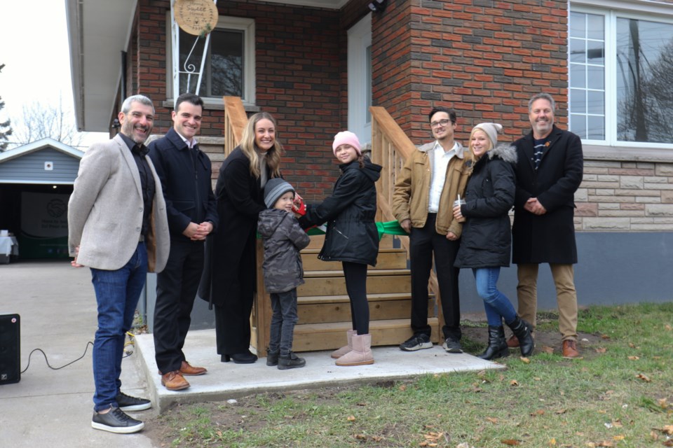 The McCoy family was joined by Sault MPP Ross Romano, Sault Mayor Matthew Shoemaker, DSSMSSAB Chair Stephanie Hopkin and DSSMSSAB CEO Mike Nadeau to cut the ribbon on 237 Goulais Ave. Friday. 