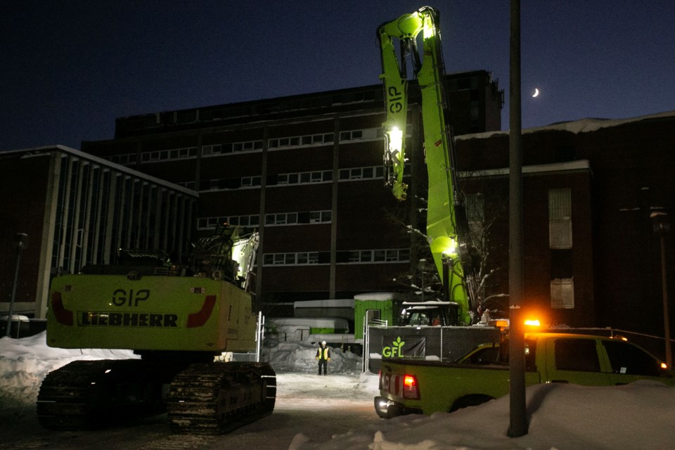 A Liebherr 956 demolition excavator drives toward the old hospital site to prepare for an eventual demolishing of the building.