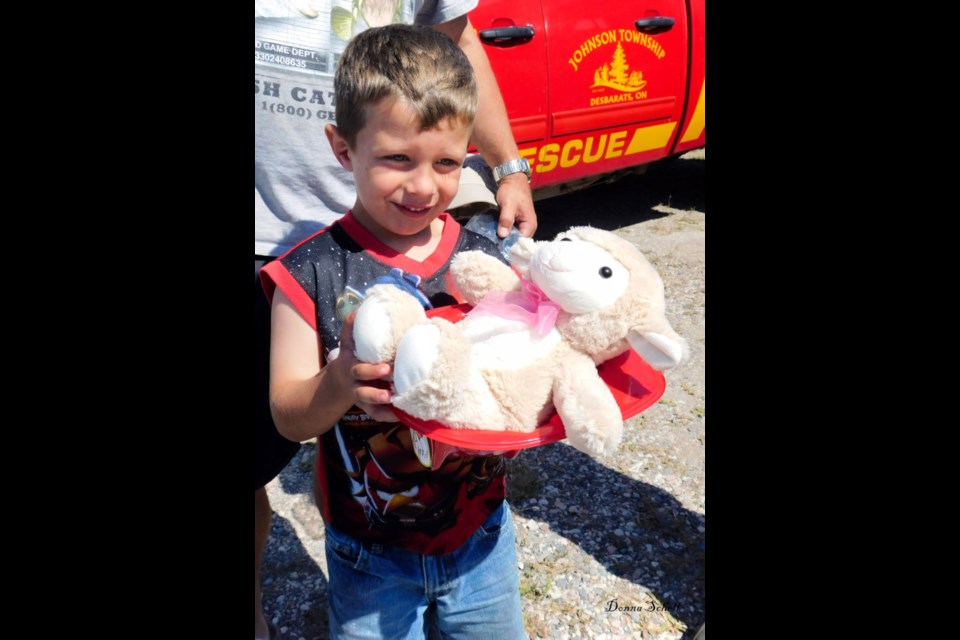 Rescue Buddies. Joshua Wamsteerker with his stuffed buddy and fireman's helmet. Photo by Donna Schell