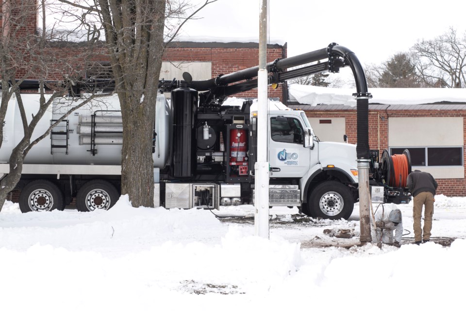 A crew uses a hose from a NEO Industrial and Environmental Services vacuum truck directly in front of Queen Elizabeth Public School on Dec. 11, 2024. 