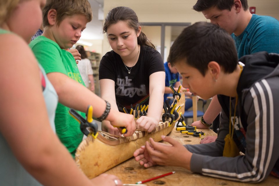 École Notre-Dame-du-Sault student work together this morning to create a hand-made birch bark canoe. Kenneth Armstrong/SooToday