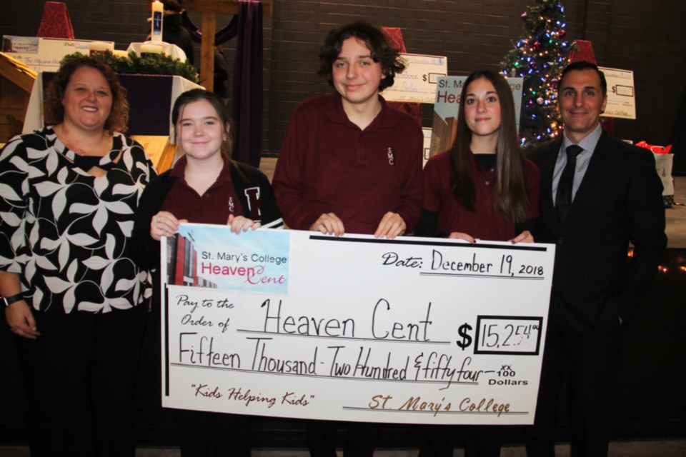 Stephanie Parniak, St. Mary’s College chaplaincy leader, St. Mary’s College students Jordyn Ralston, Zachary Lacelle and Alyssa Ritchie and Christopher Czop, St. Mary’s College vice principal, with a cheque for $15, 254 raised by St. Mary’s students in the 2018 Heaven Cent campaign, Dec. 18, 2018. Darren Taylor/SooToday