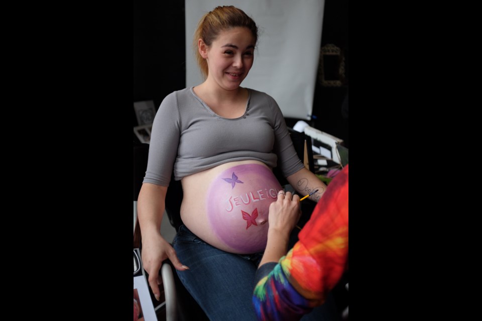 Kandyn Bond-Miallet three days before her C-section getting her belly painted with her soon-to-be baby girl Jeuleigh's name. Pregnant-belly painting and photograph sessions were provided by Perfectly Painted and RAD.imagery at the Bumps, Babies, and Beyond Expo on Sunday. Photo by Jeff Klassen for SooToday