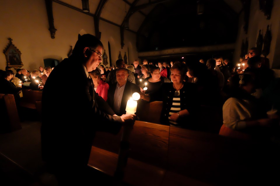 The light of Christ is passed on at Precious Blood Cathedral on Saturday night. Photo by Jeff Klassen for SooToday.