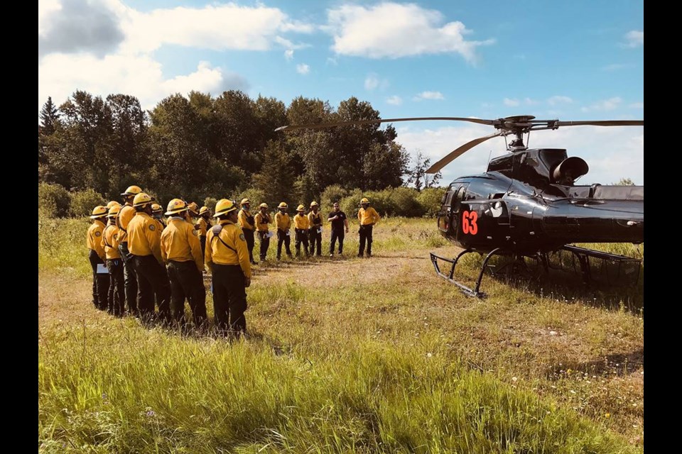 Mexican forest fire fighters receive a helicopter briefing near the Cochrane 7 fire