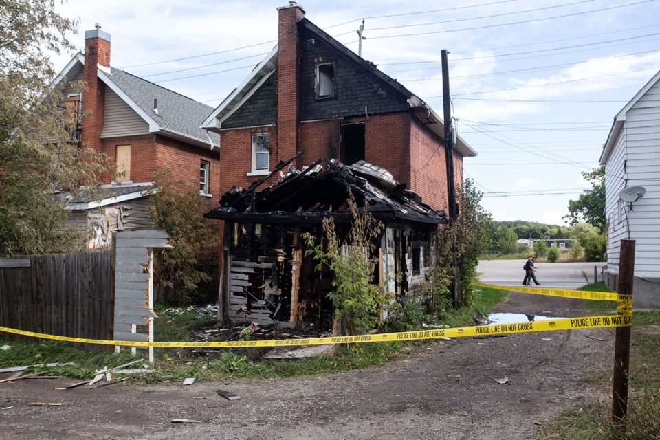 Police tape surrounds a boarded-up home at 163 Wellington St. E. after an apparent shed fire.