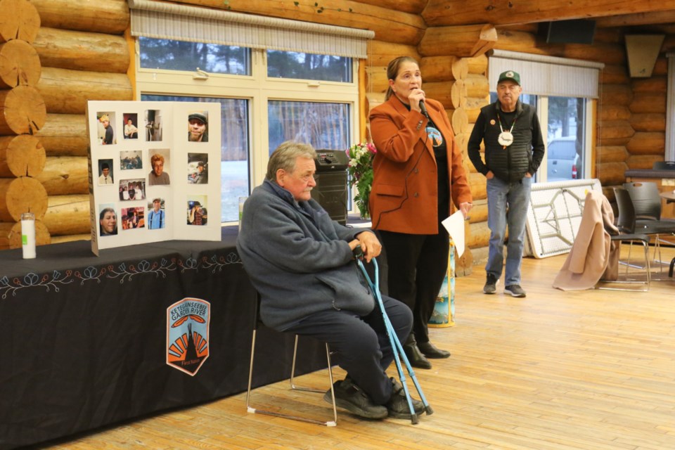 Garden River First Nation Chief Karen Bell, middle, speaks to people gathered for a vigil held at Garden River Community Centre for Jake Corbiere Friday as Elder Willard Pine, left, and Darrell Boissoneau, right. look on. 