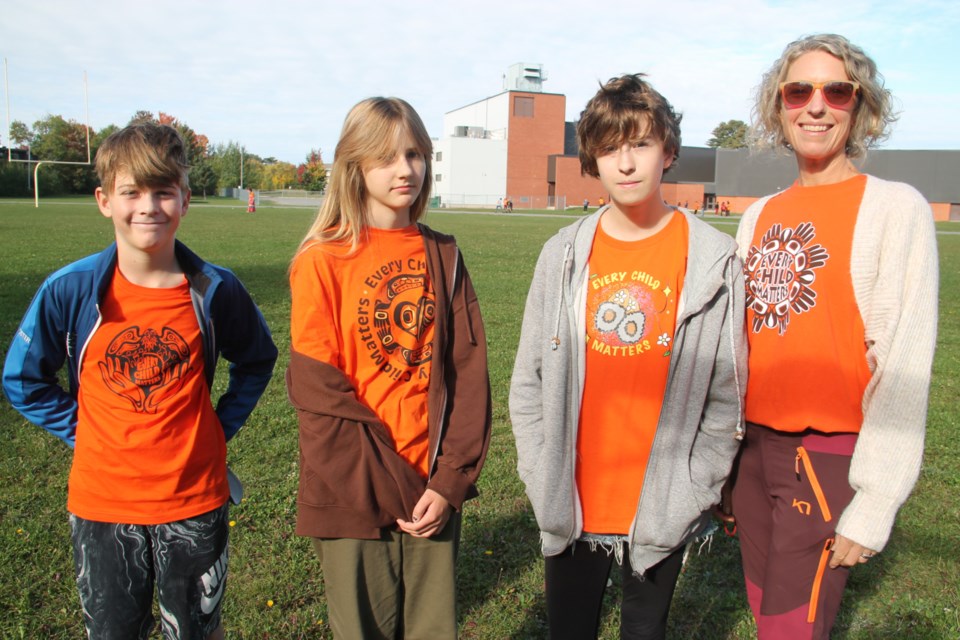 White Pines Collegiate Grade 8 students Quinton Foster, Eila Kuisma and Grace Cuthbertson with intermediate teacher Nancy Neave after a National Day for Truth and Reconciliation honour walk held at the high school’s track, Sept. 28, 2023.  