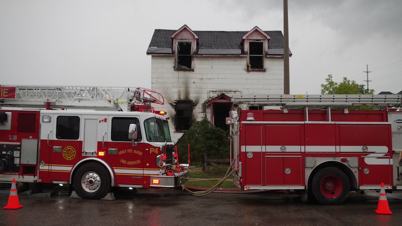 Firefighters and police are pictured on the scene of a house fire on Albert Street West. Michael Purvis/SooToday