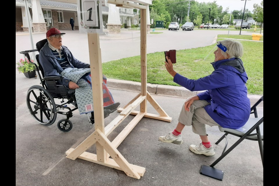 Blaine Konzuk receives a visit at Extendicare Maple View rest home from wife Nancy, outdoors and separated by plexiglass, Nancy wearing a face shield,  June 24, 2020. Darren Taylor/SooToday 